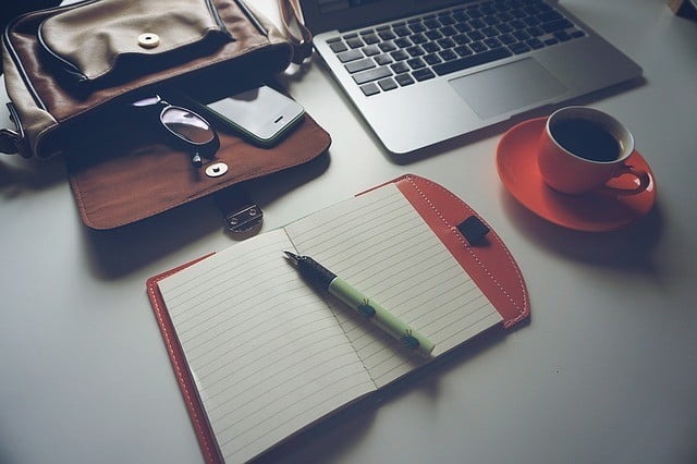 A notebook and pen on the desk demonstrating how to find obsession.