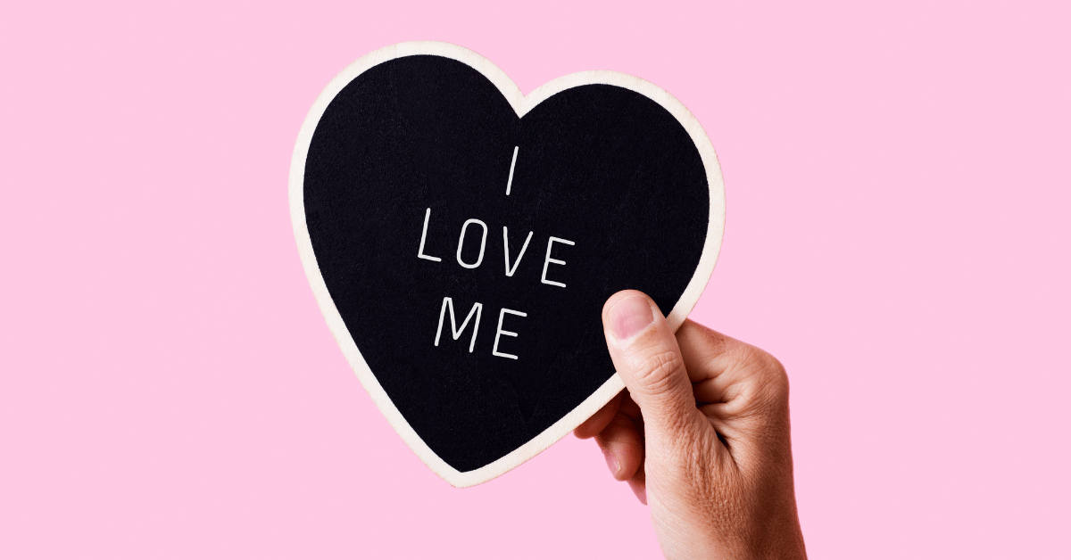 A heart-shaped sign with the phrase 'I LOVE ME', symbolising the concept of self-esteem.