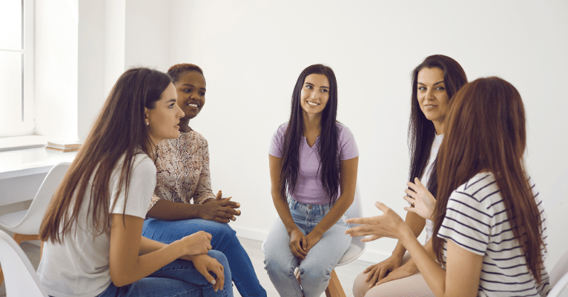 A group of women discussing and sharing goals with empathy and open-mindedness