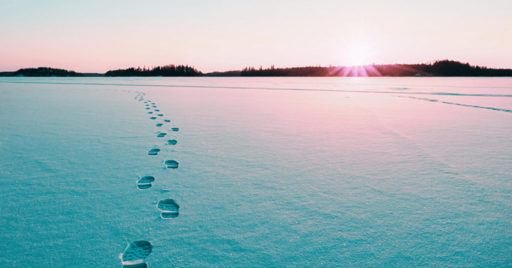 Footprints leading towards a vibrant sunset, representing the journey of personal growth and self-discovery.