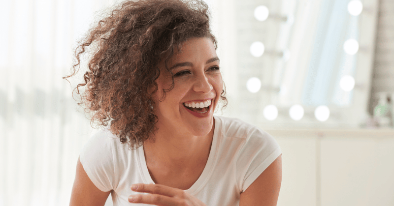 A woman with a big smile, signifying the positive effect of implementing 30 day challenge ideas for minimalism and sustainability