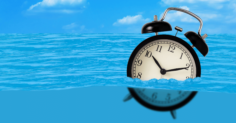 Alarm clock on the water, depicting the concept of time wasting activities