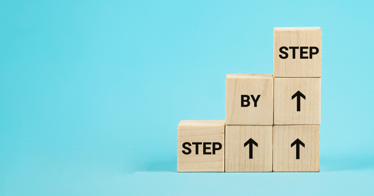 Text STEP BY STEP on wooden cubes, demonstrating the concept of Dr David Harold Fink 6 steps to success