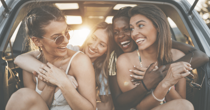 A group of women looking at each other smiling depicting the importance of promises to others in a relationship