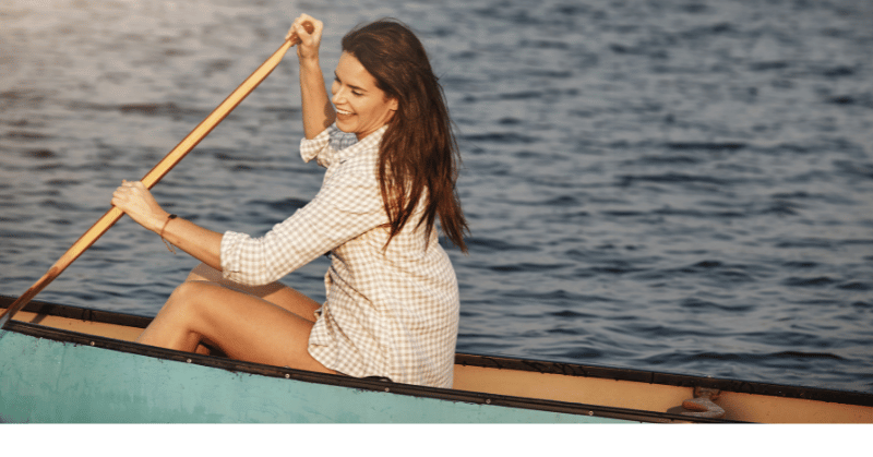 Woman rowing a boat looking happy depicting live your life and stop worrying about others' opinions 